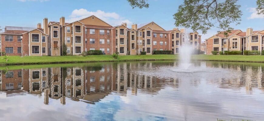 Property water feature and surrounding greenery at Regency Gardens in Orlando, FL, with a view of the exterior property buildings